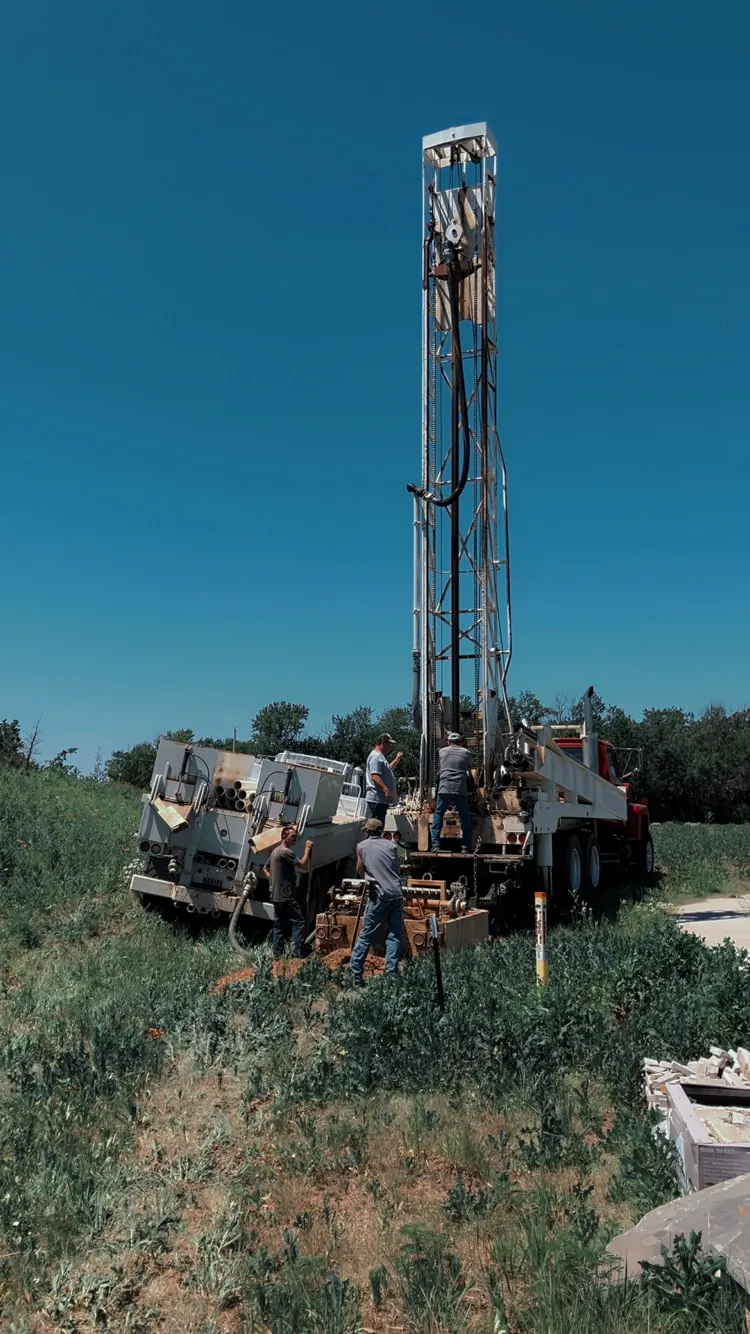 Chase Drilling LLC red drilling rig truck at a residential property in Wichita, KS preparing to drill a geothermal well for a ground source heat pump system