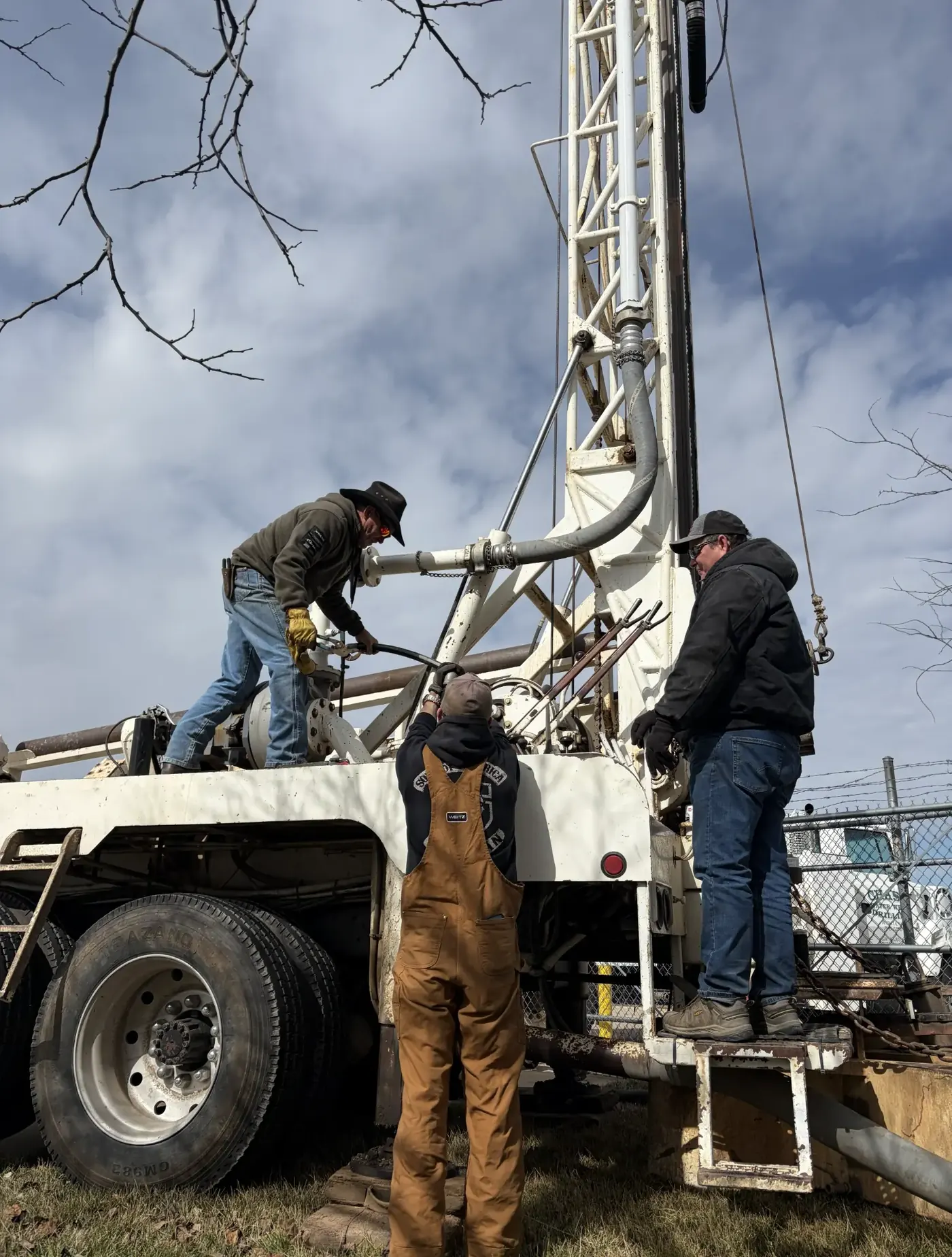 Chase Drilling crew members working at a geothermal well drilling site in Kansas, with drilling equipment and safety gear visible