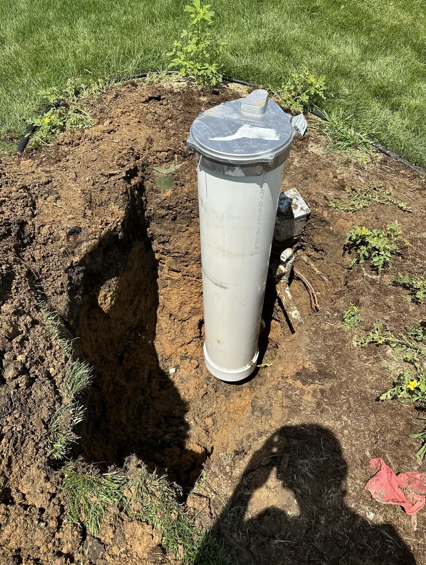 Completed lawn irrigation well installation in a Wichita, KS residential backyard showing the wellhead and pump system ready for connection to a sprinkler system